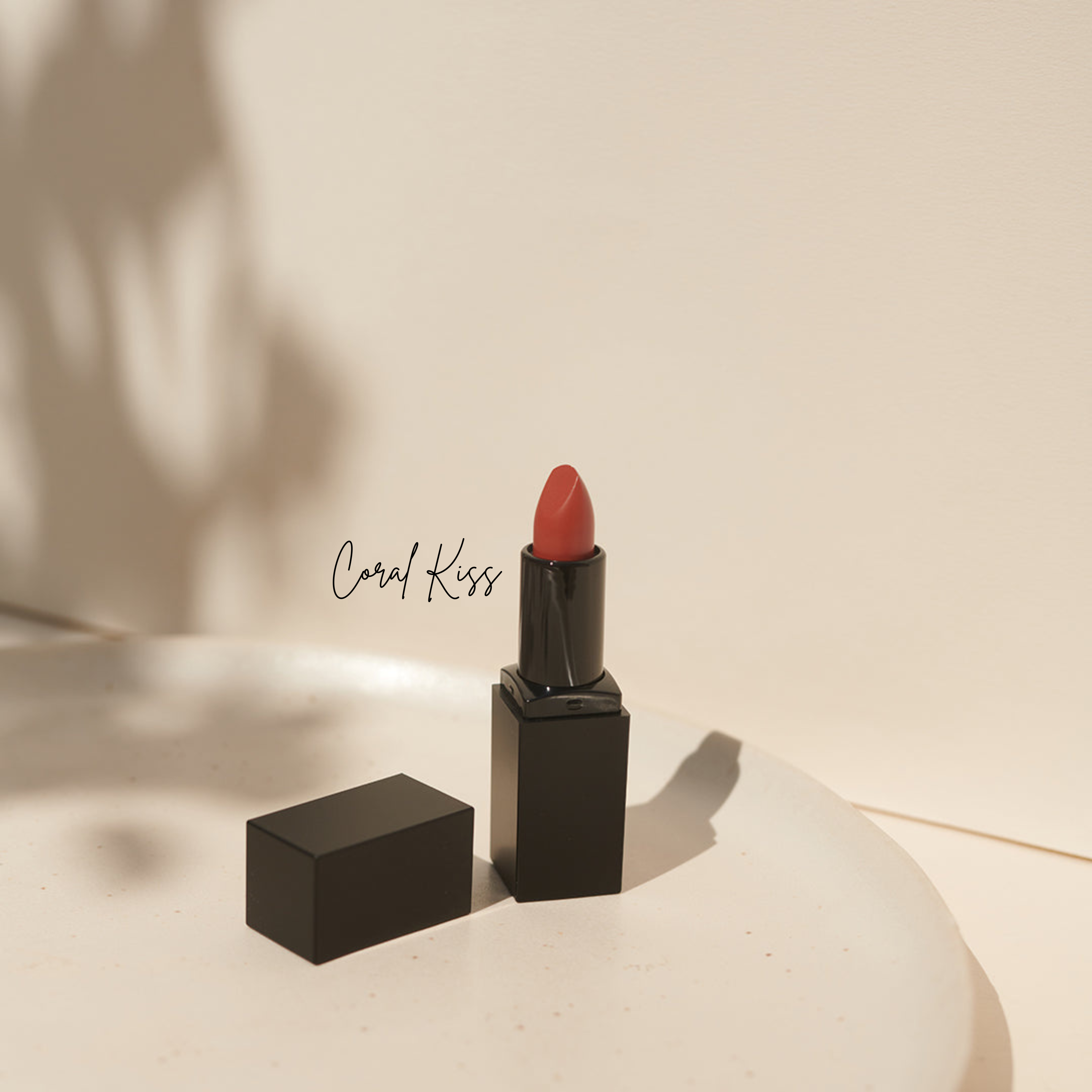 Ein korallenfarbener, tierversuchsfreier Lippenstift von Thats me Organic® in einem eleganten schwarzen Etui liegt auf einem weißen Teller, mit "Coral Kiss" kunstvoll daneben geschrieben.