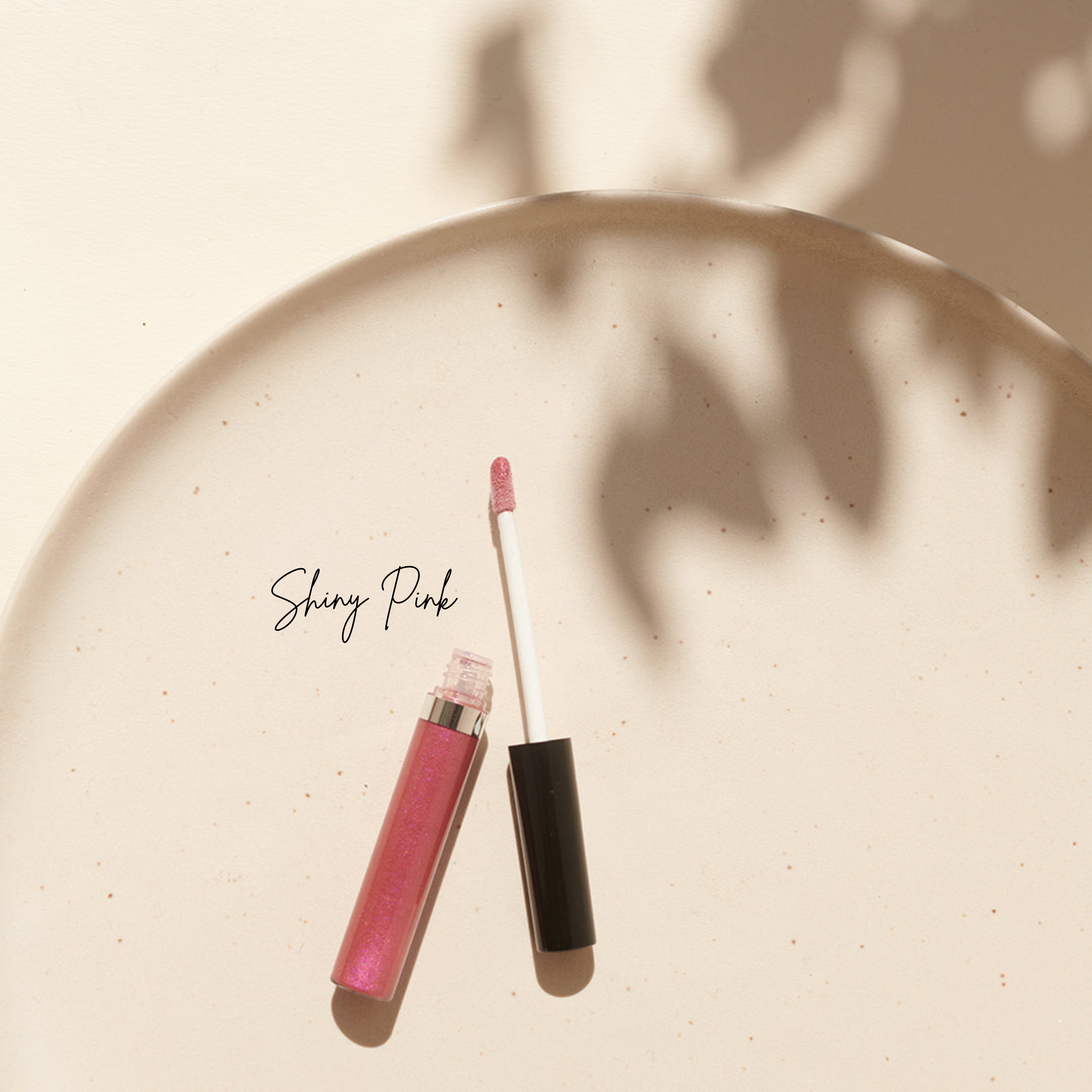 Thats me Organic® Shiny Pink Bio-Lipgloss mit schwarzer Kappe und Applikator auf einer hellen Oberfläche - Ihre go-to vegane Lippenpflege für ein glänzendes Finish.