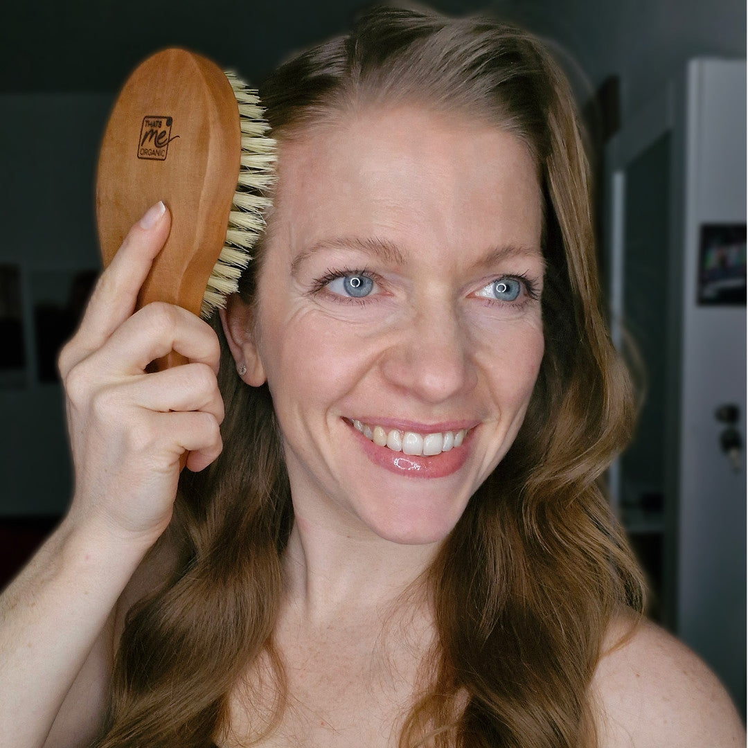 Eine lächelnde Frau mit langem Haar bürstet sich den Kopf mit der Thats me organic® vegane Haarbürste, die zur Förderung des Haarwachstums entwickelt wurde.