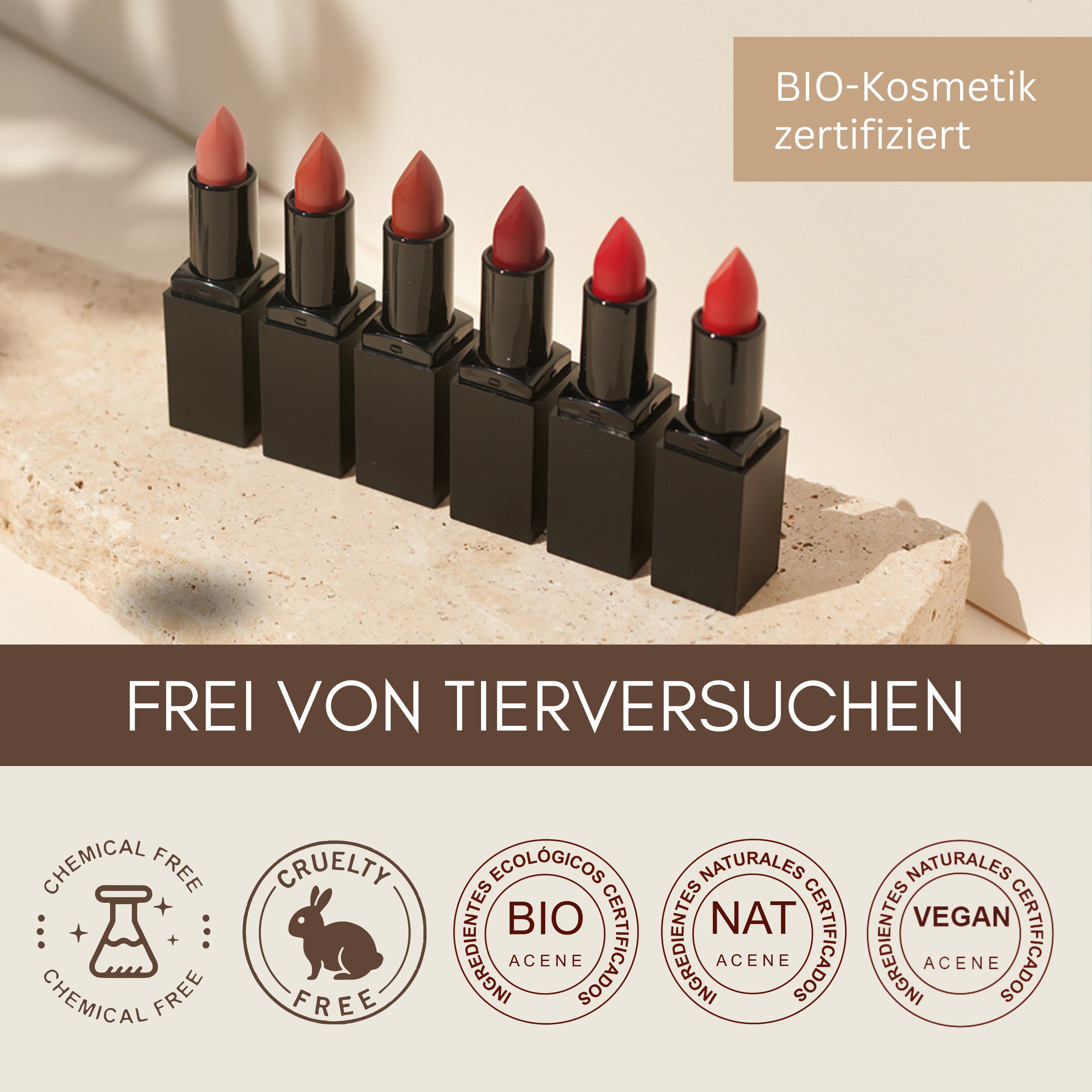 Sechs Nuancen der Thats me Organic® tierversuchsfreien Lippenstifte in schwarzen Etuis ruhen auf einer beigen Oberfläche, die durch grausam-freie und umweltfreundliche Produktplaketten hervorgehoben wird.