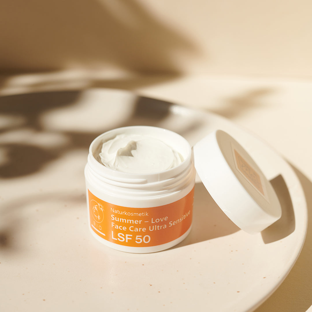 Geöffneter Tiegel von Thats me Organic® Love Face Care Ultra Sensitive Sonnencreme LSF 50+ ohne Titandioxid auf weißem Teller, bietet effektiven UVA- und UVB-Schutz.