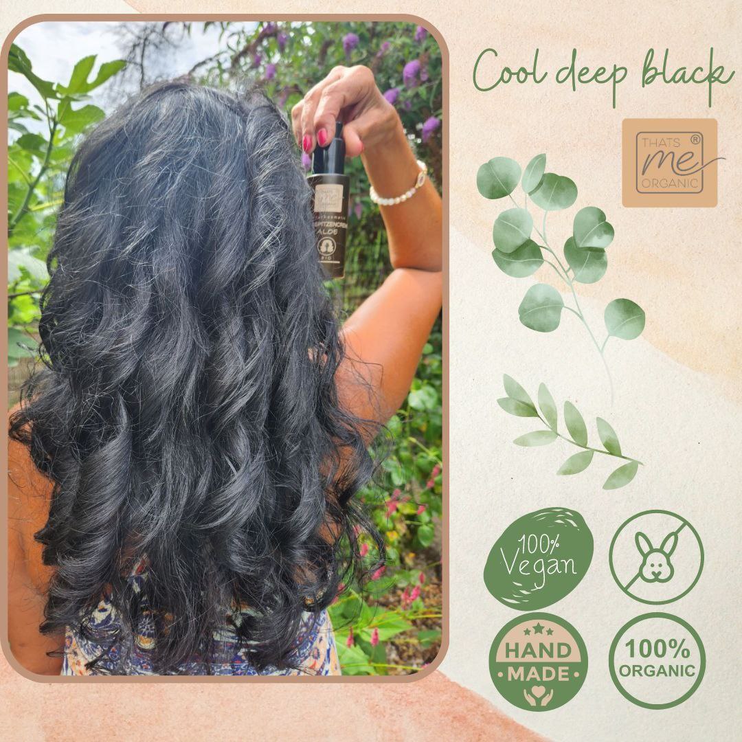 Frau mit langen, gewellten schwarzen Haaren, die eine Flasche mit einem Haarprodukt hält; Symbole für vegane und biologische Produkte.