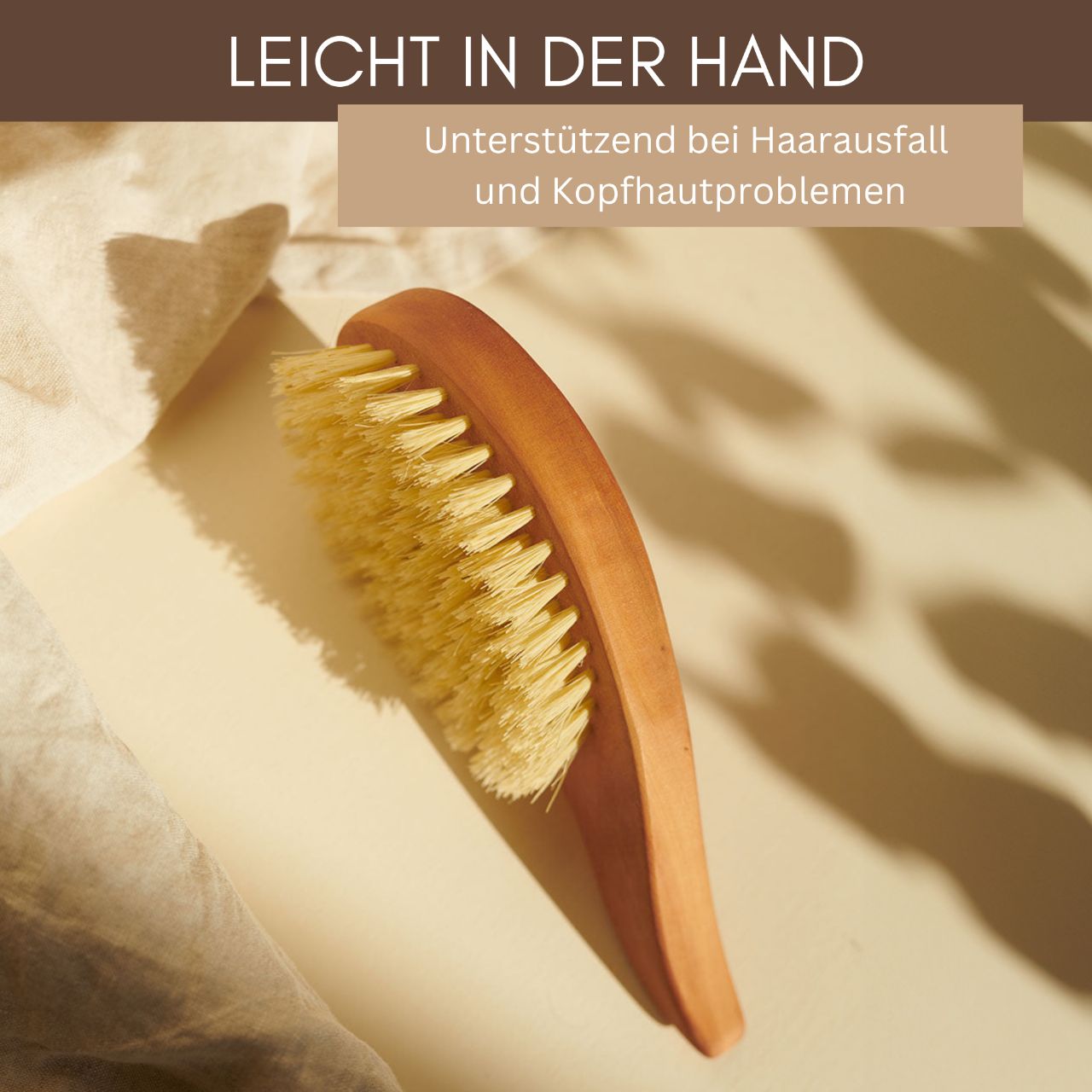 Die Thats me Organic® vegane Holzbürste in Tropfenform mit hellen Borsten fördert das Haarwachstum. Präsentiert auf beigem Untergrund im Sonnenlicht mit deutschem Text darüber.