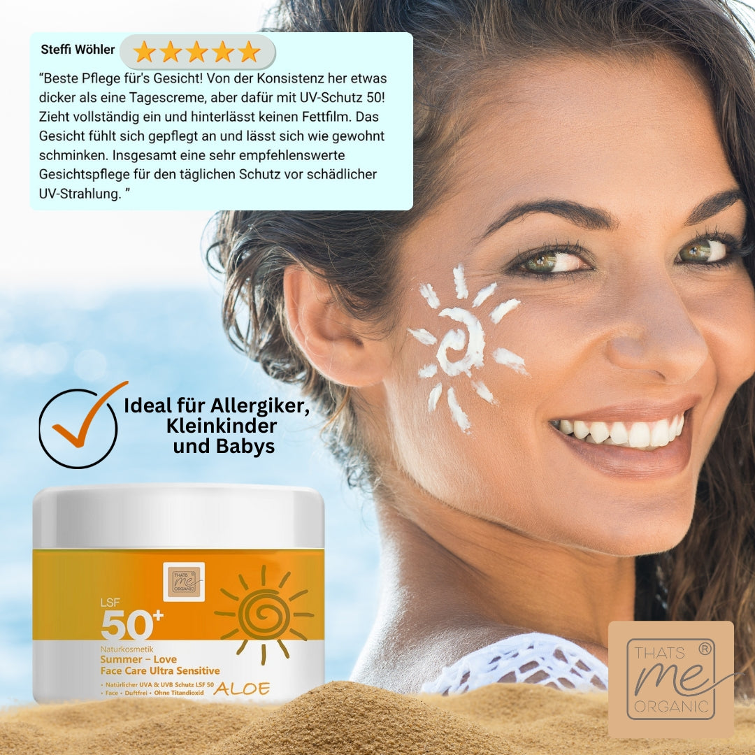 Lächelnde Frau mit Thats me Organic® Sonnencreme LSF 50+ auf der Wange, Sonnenschutztiegel im Sand; ideal für empfindliche Haut, frei von Titandioxid, bietet zuverlässigen UVA/UVB-Schutz.