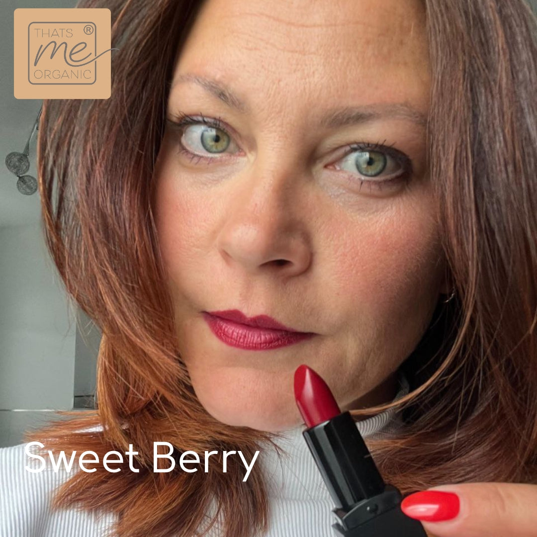 Die Frau mit rotem Lippenstift hält einen Lippenstift; im Eck steht "Sweet Berry" und "Thats me Organic®" - unser veganer Bio-Lippenstift für natürliche Lippenpflege.