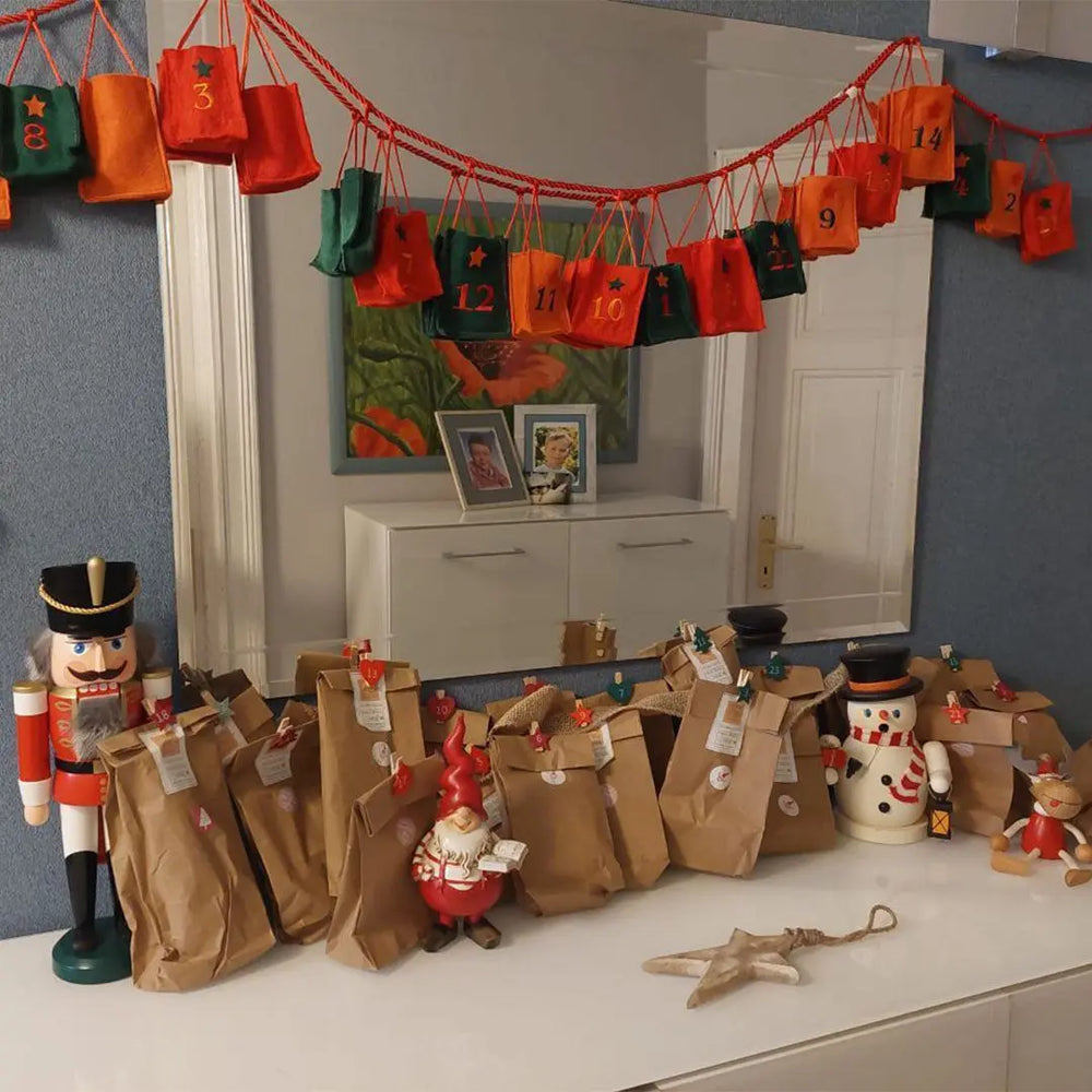 Der Adventskalender steht dekoriert auf einer Kommode