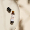Thats me Organic® Brown Anti-Mücken-Roll-On mit schwarzer Kappe auf beiger Keramikplatte in natürlichem Licht - Ihr natürlicher Mückenschutz und praktisches Hausmittel gegen Mücken.