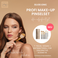 Eine Frau hält einen Schminkpinsel mit dem Thats me Organic® Profi-Pinsel Set - bestehend aus 7 veganen Schminkpinseln - neben sich auf einem beigen Hintergrund.