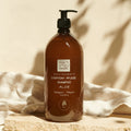 Eine braune Pumpflasche Thats me organic® BIO-Shampoo mit Bio-Aloe steht auf einer Steinfläche, umrahmt von weichem Stoff und sanften Schatten, und zeigt Naturkosmetik pur.