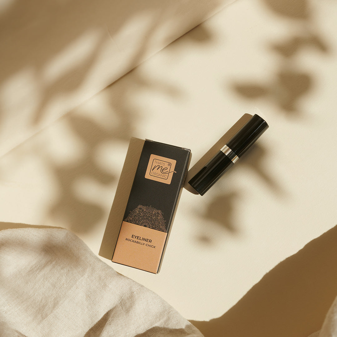 Thats me Organic® Bio Eyeliner ohne Titandioxid in seiner Box auf cremefarbener Oberfläche mit weichen Schatten und beigefarbenem Stoff - perfekt für empfindliche Augen.