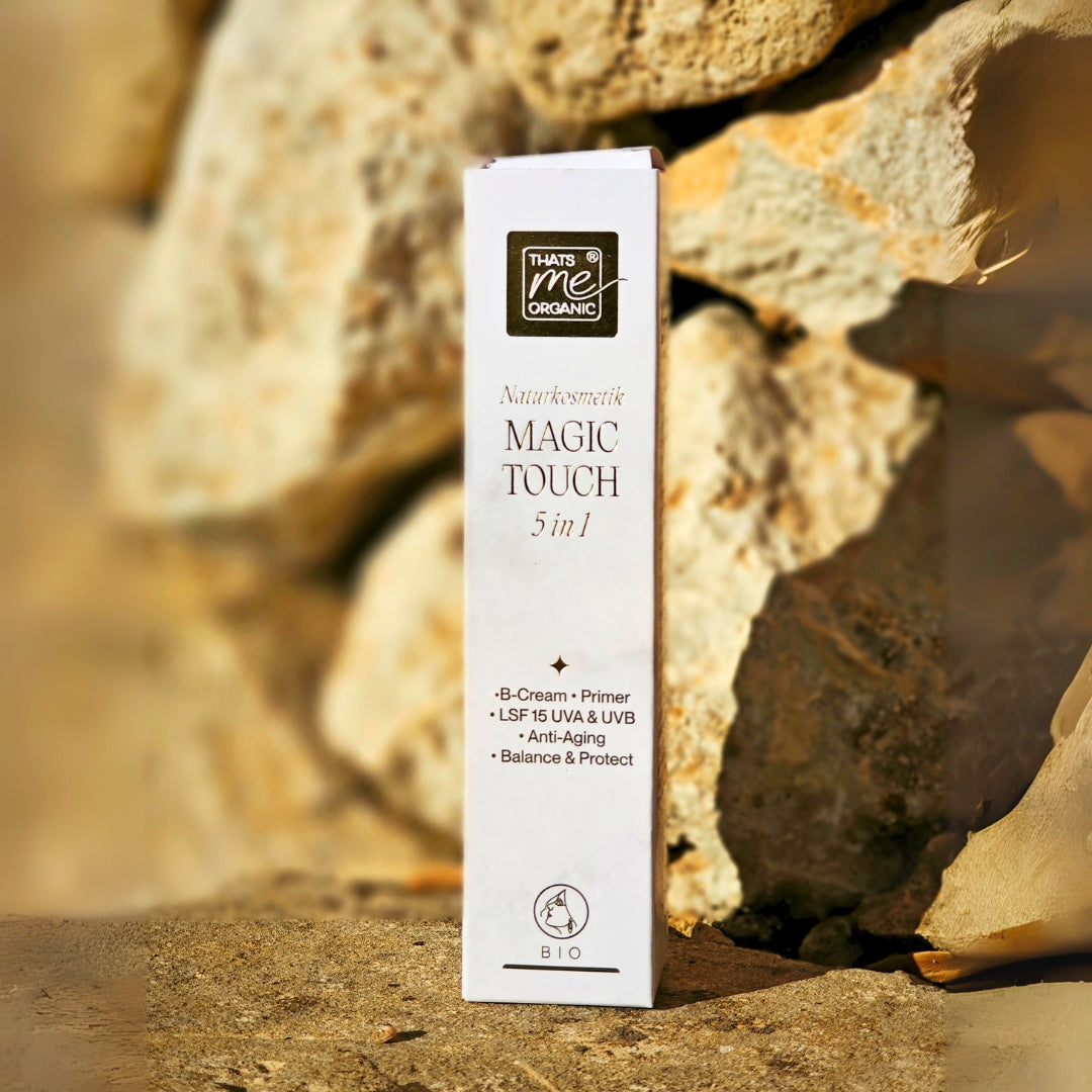 Die Thats me organic Magic Touch 5 in 1 steht verpackt im neuen Design auf einer Steinmauer im Sonnenlicht.